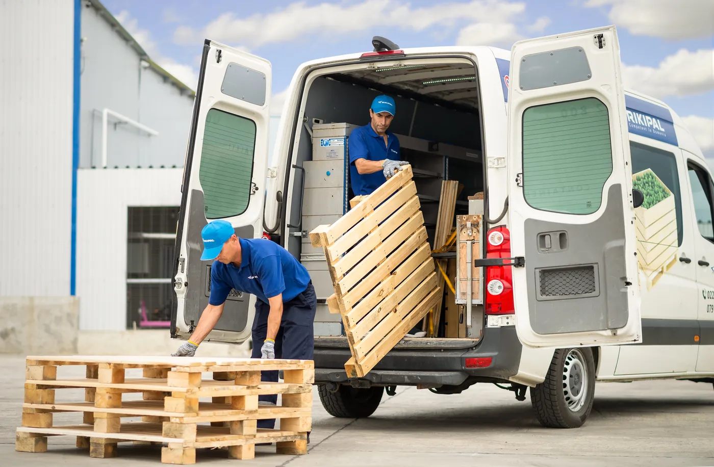 Muncitori RIKIPAL descarcă containere din autoutilitară